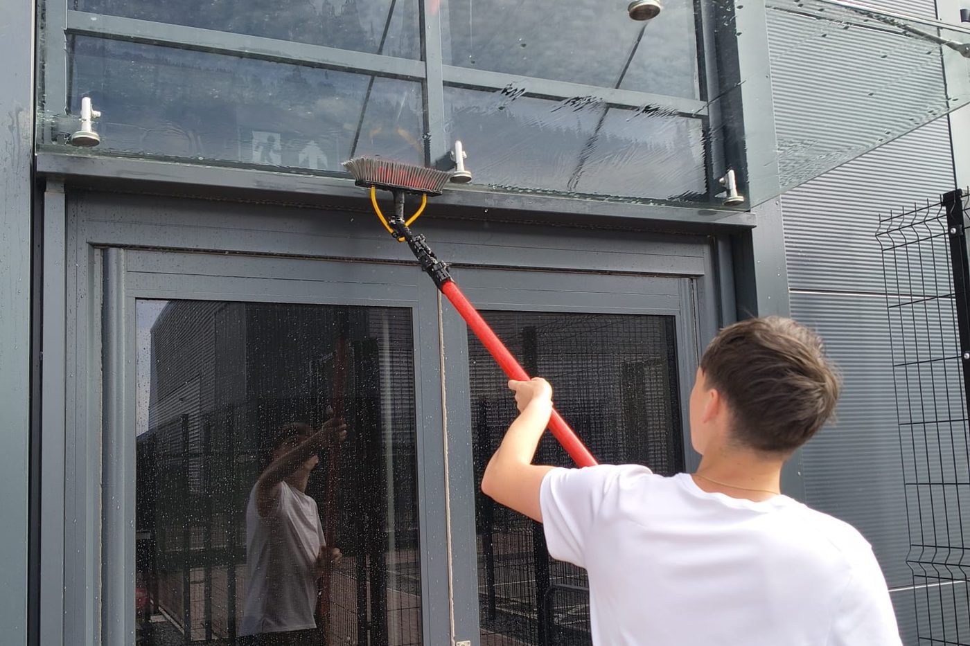 Cleaning a glass canopy with a water-fed pole